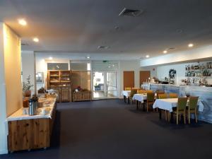 un restaurant avec des tables, des chaises et un comptoir dans l'établissement PAN Dom Pracy Twórczej w Wierzbie, à Wierzba