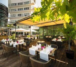 a restaurant with tables and chairs and a building at Parkhotel Hall in Tirol in Hall in Tirol