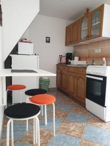 a kitchen with two stools and a stove top oven at Apartmani Pejo in Gostinjac