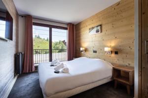 a bedroom with a bed and a large window at Résidence Daria-I Nor by les Etincelles in L'Alpe-d'Huez +79 photos