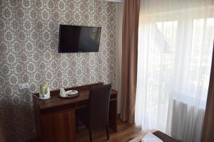 a room with a desk and a television on a wall at Dom Bursztynowy in Jantar
