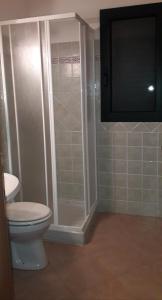 a bathroom with a toilet and a glass shower at Agriturismo La Tuva in Padru
