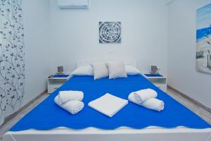 a bedroom with a blue bed with white pillows at Apartments Magdalena in Hvar