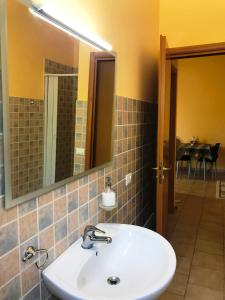 a bathroom with a sink and a mirror and a table at Giardino - Poggio del Casale - Affittacamere - landlords in San Cataldo