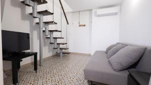 a living room with a couch and a tv at Casa das 3 Andorinhas in Olhão