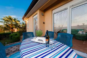 una mesa con una botella de vino y copas en el patio en Villa Istria, en Poreč