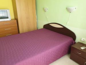 a bedroom with a purple bed and a tv at apartament Sea Star in Byala +27 photos