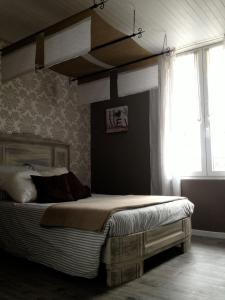 a bed in a room with a large window at Chambres d'hôtes Le Pessac in Vielmur