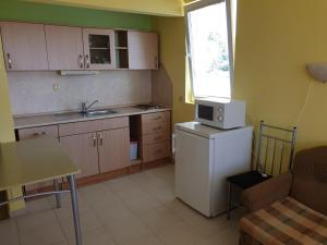 a small kitchen with a white refrigerator and a window at apartament Sea Star in Byala
