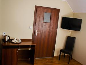 a room with a wooden door and a desk and a chair at Dom Bursztynowy in Jantar