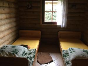 2 Betten in einem kleinen Zimmer mit Fenster in der Unterkunft Domy z bali Debina in Debina