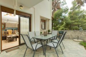 a dining room with a table and chairs on a patio at Izabella Sea Side Villa in Siviri