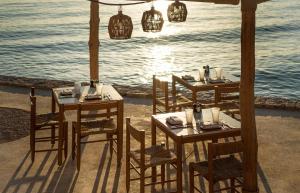 two tables and chairs with the ocean in the background at Four Seasons Astir Palace Hotel Athens in Athens
