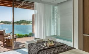 a bedroom with a bed with a view of the ocean at Four Seasons Astir Palace Hotel Athens in Athens