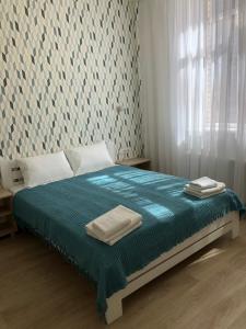 a bedroom with a bed with blue sheets and a window at Apartment Gagarinsky in Arcadia in Odesa