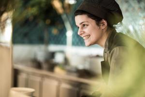 a woman wearing a hat and smiling at Four Seasons Astir Palace Hotel Athens in Athens