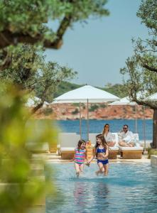 two girls in the swimming pool at a resort at Four Seasons Astir Palace Hotel Athens in Athens