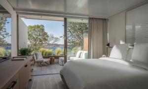 a bedroom with a large bed and a large window at Four Seasons Astir Palace Hotel Athens in Athens