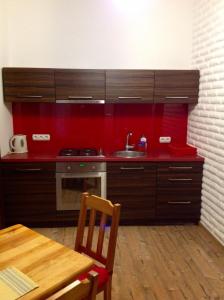a kitchen with a sink and a red wall at Apartament Berko in Kraków
