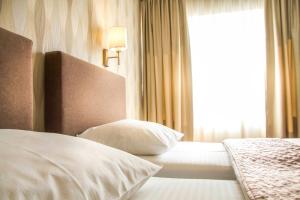 a hotel room with a bed and two lamps at Philia Hotel in Podgorica