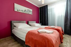 two beds in a room with pink walls at Apartamenty Sun Seasons 24 - Posesja Bałtycka in Grzybowo