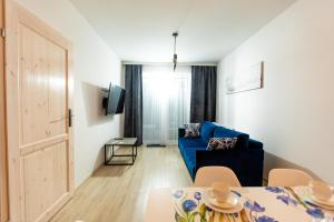 - un salon avec un canapé bleu et une table dans l'établissement Apartamenty Sun Seasons 24 - Posesja Bałtycka, à Grzybowo