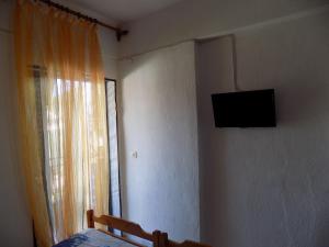 ein Schlafzimmer mit einem Bett und einem Fernseher an der Wand in der Unterkunft DIALEKTI STUDIOS in Toroni