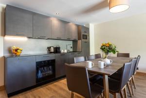 a kitchen with a wooden table and a dining room at Résidence Daria-I Nor by les Etincelles in L'Alpe-d'Huez