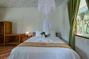 a bedroom with a bed with a stuffed animal on it at Tra Vinh Lodge in Nguyệt Hạng