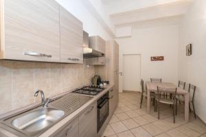 eine Küche mit einem Waschbecken und einem Tisch darin in der Unterkunft Finalborgo - Casa Nanetti 6 posti in centro in Finale Ligure