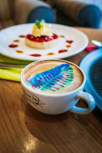 a cup of coffee on a table with a plate of food at Hotel Jerbourg in St. Peter Port