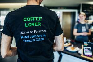 un homme portant une chemise avec les mots "amant de café" sur le dos dans l'établissement Hotel Jerbourg, à Saint-Pierre-Port