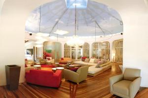 a living room with couches and chairs and a chandelier at Villa Don Vito in Tamarindo