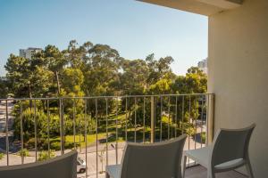 a balcony with chairs and a view of a park at Troia Residence by The Editory - Apartamentos Marina in Troia
