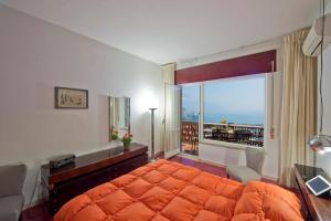 ein Schlafzimmer mit einem orangenen Bett und einem Balkon in der Unterkunft Appartamento Belvedere in Amalfi