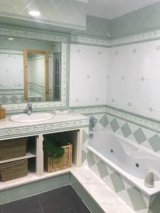 a bathroom with a tub and a sink and a mirror at ROOMQUEO-Only Adults in Barbate
