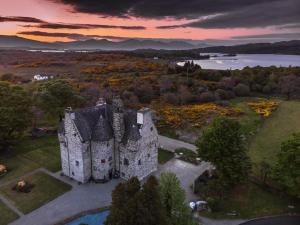 an aerial view of an old castle with a lake at Barcaldine Castle in Oban