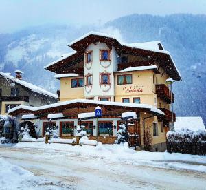 a large building with snow on top of it at Hotel Viktoria & Landhaus Joggl in Mayrhofen