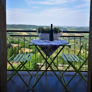 einen Tisch mit einer Flasche Wein und zwei Stühlen in der Unterkunft Il Corso in Montepulciano