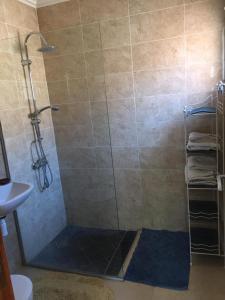 y baño con ducha y puerta de cristal. en Riad Lalla Zahra en Marrakech