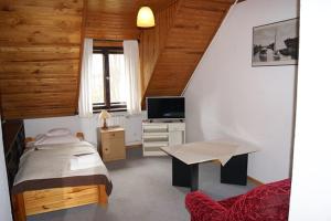 une chambre avec un lit, une table et une télévision dans l'établissement PAN Dom Pracy Twórczej w Wierzbie, à Wierzba