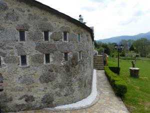un antiguo edificio de piedra con un camino al lado en Casa Cástor O Valadouro Galicia, en Alaje