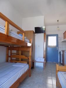 a bedroom with two bunk beds and a blue door at DIALEKTI STUDIOS in Toroni