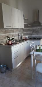 a kitchen with white cabinets and a table and a stove at Palazzo Mosca in Sannicola