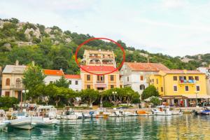 a group of boats in the water in front of a building at Apartments Andrea in Baška