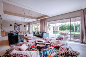 ein Wohnzimmer mit Möbeln und einem großen Fenster in der Unterkunft PALAIS SOHAN in Marrakesch