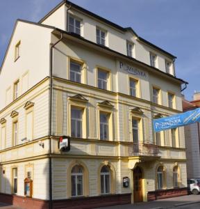 a large white building on the corner of a street at Penzion Pomnenka in Luhačovice