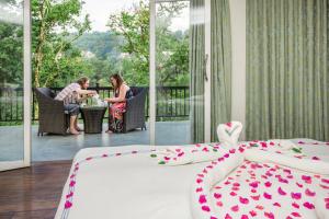 two women sitting at a table in a room with a bed at Viyana Boutique Hotel in Kandy