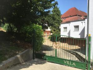 a green gate in front of a white house at Kiss Villa in Balatonföldvár