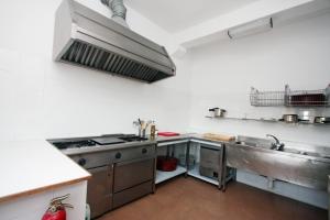 a kitchen with a stove and a sink in it at Albergue de La Estación del Río Lobos in Hontoria del Pinar